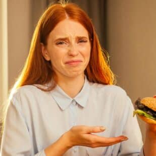woman looking disgusted at burger.