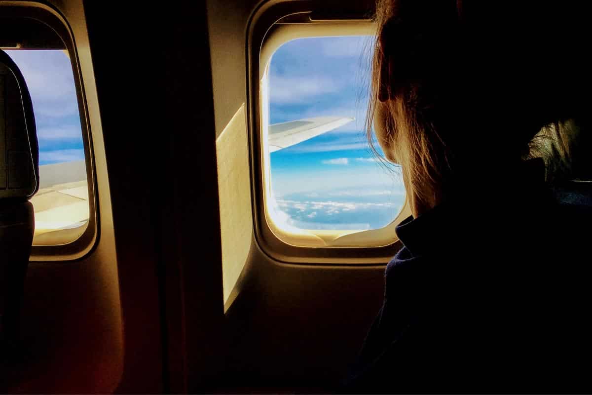 woman on plane looking out window.
