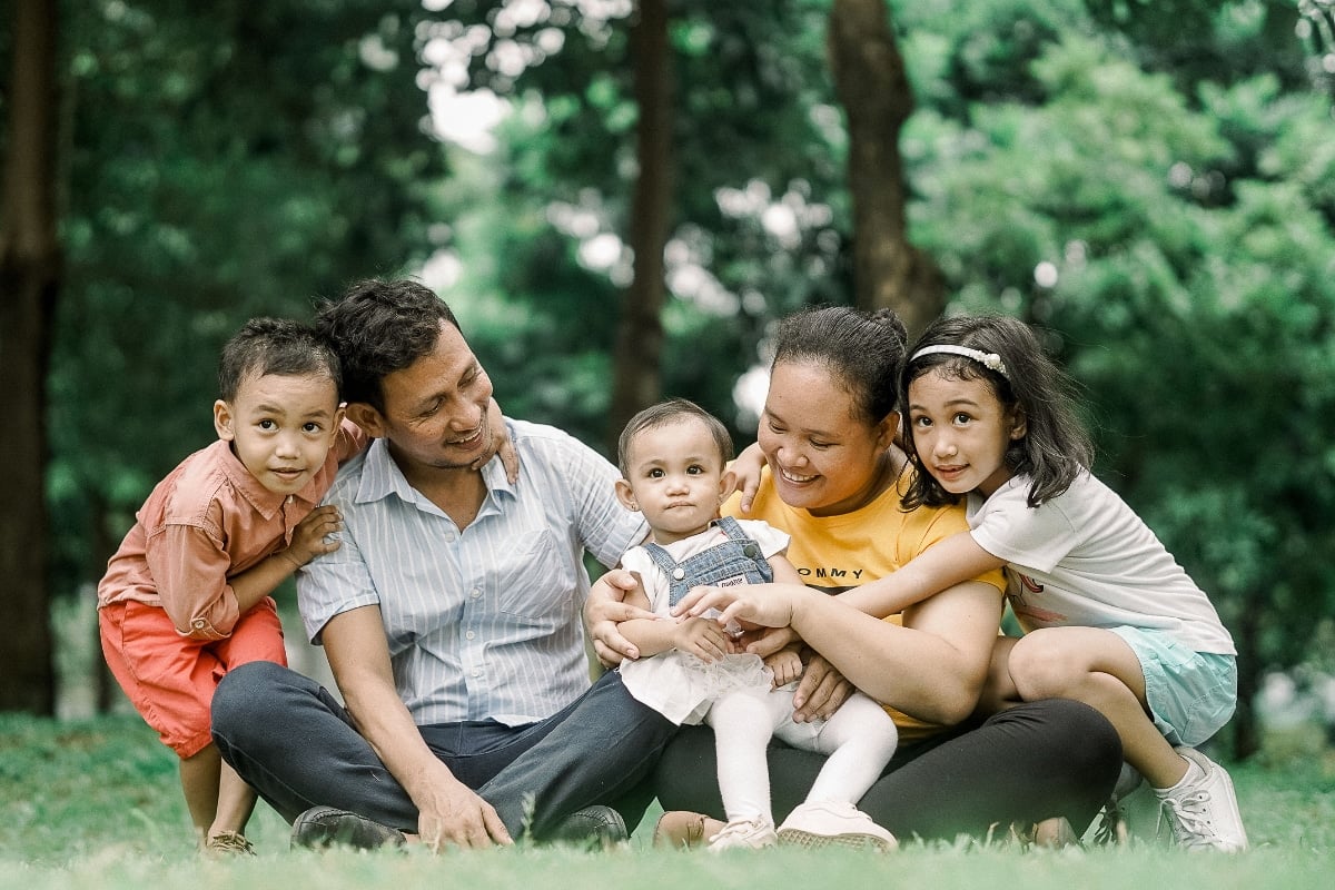 Happy family sitting on grass.