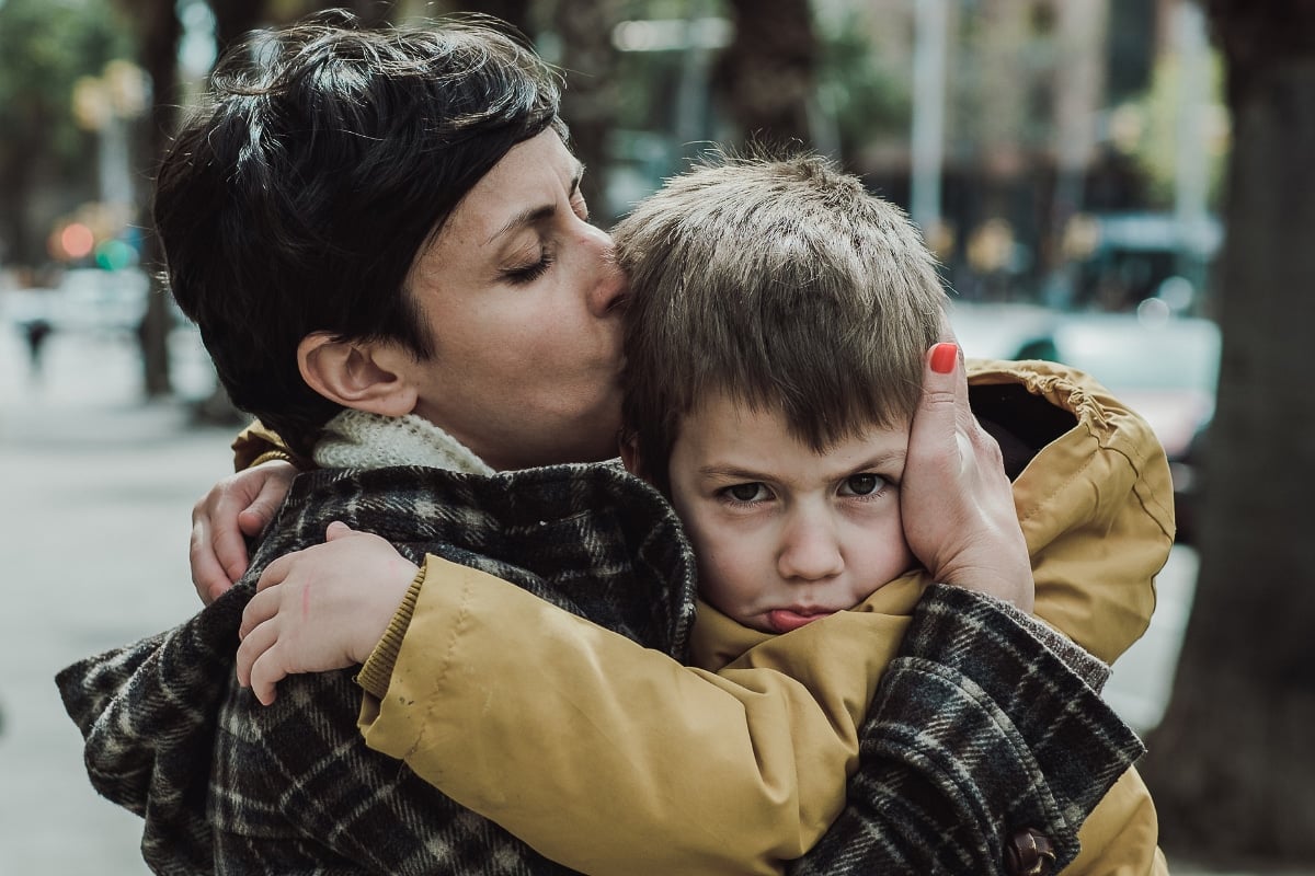 Mom hugging and kissing son.