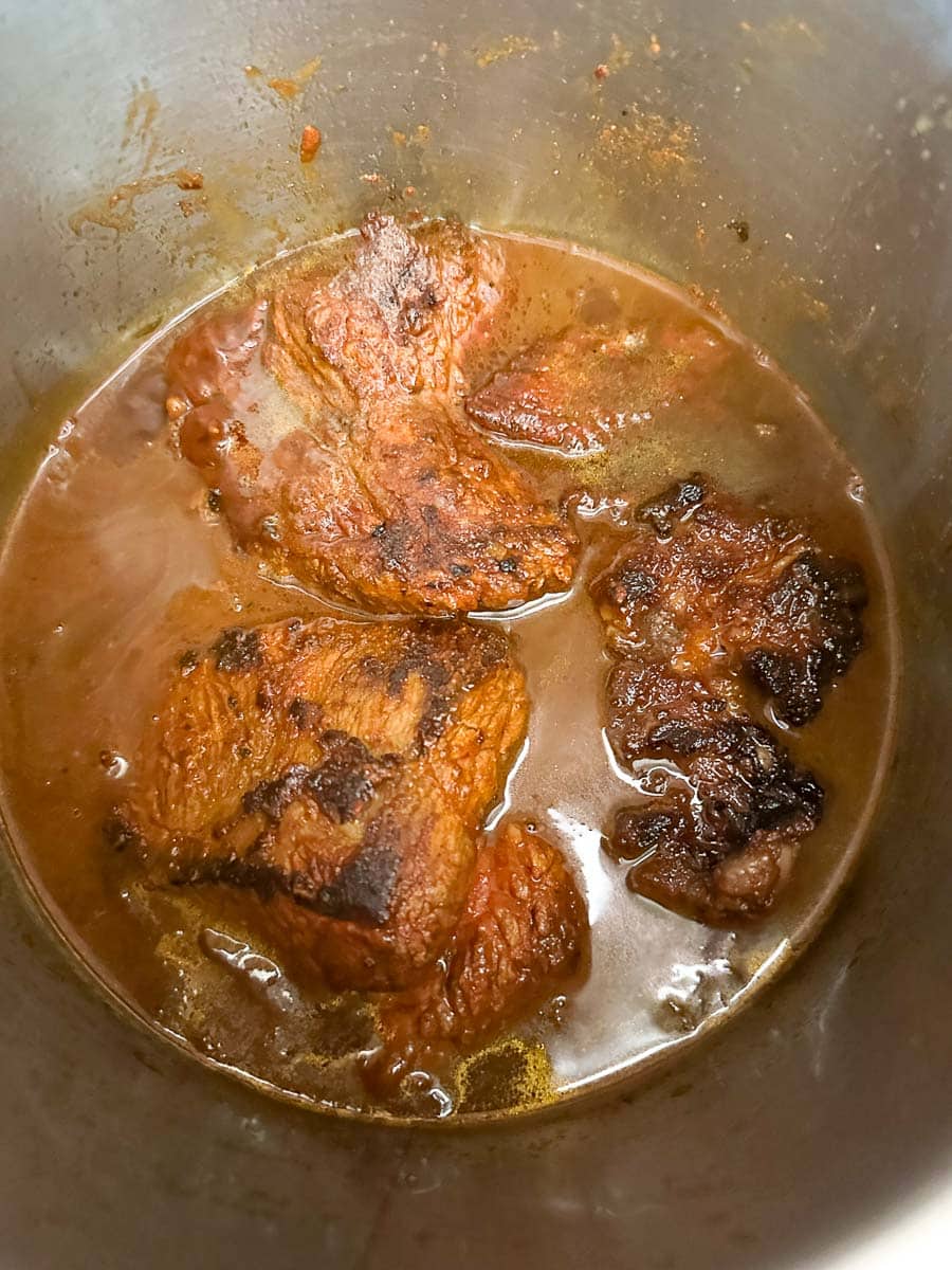 browned brisket in Instant pot with sauce.