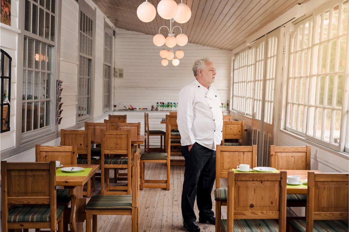 chef looking pensive in empty restaurant.
