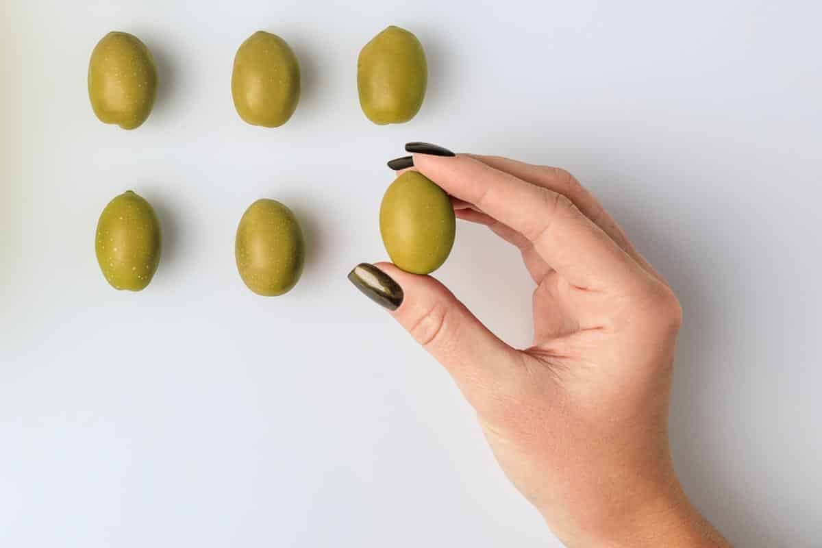 one olive held in hand.