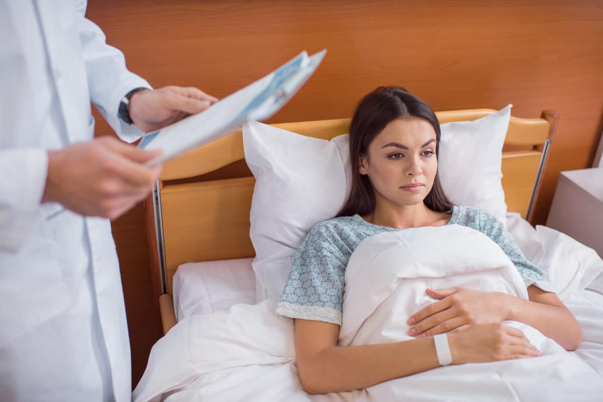 woman in hospital bed being ignored.