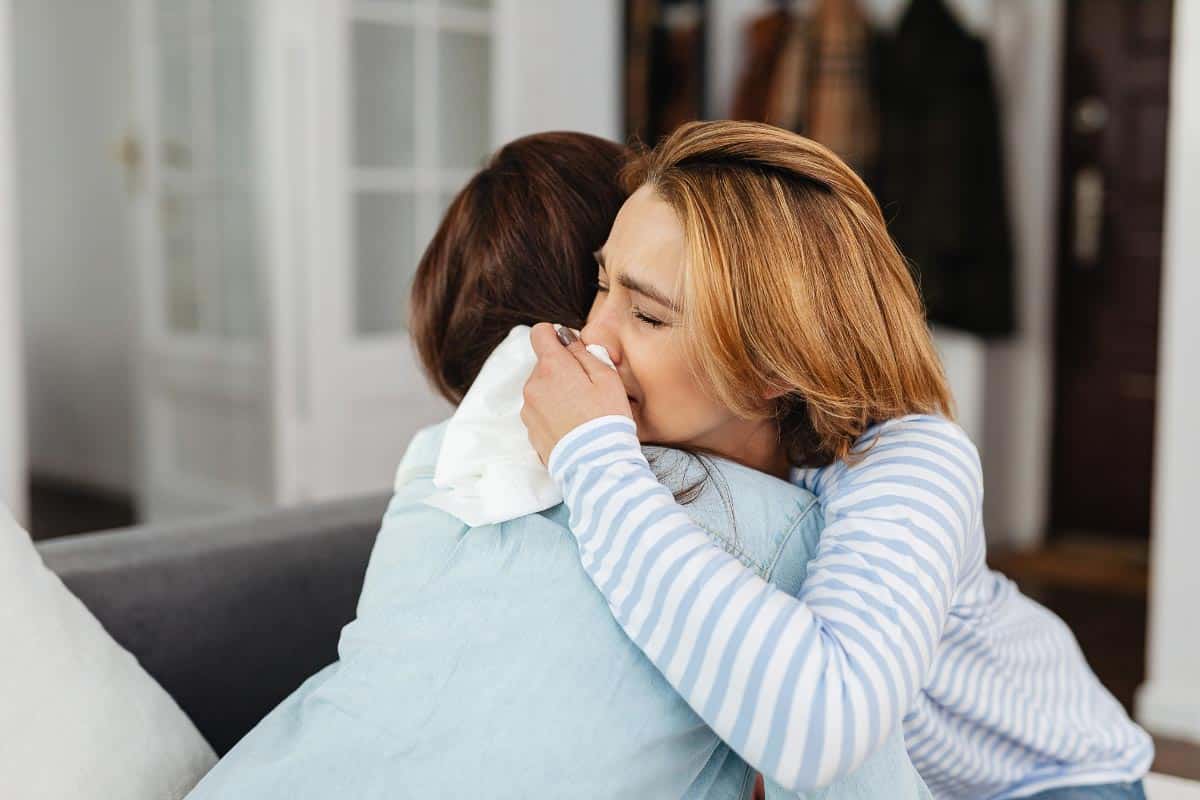 women hugging and crying.