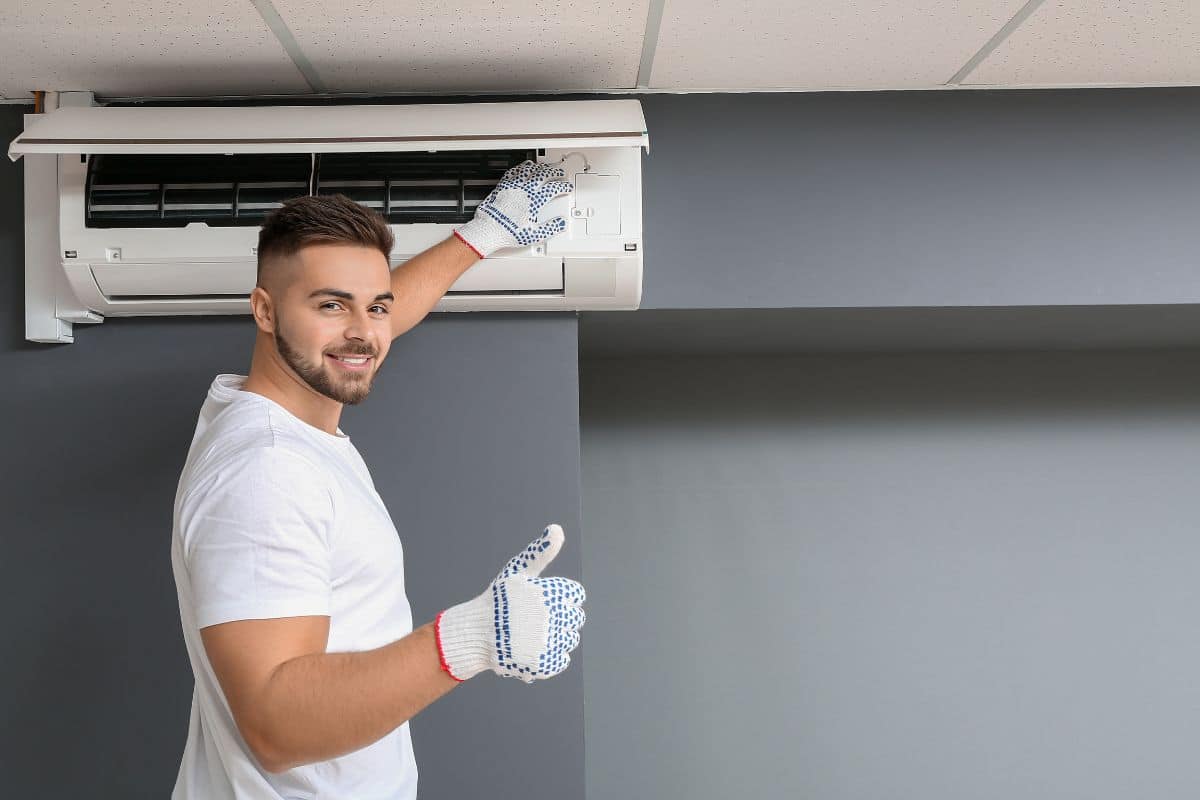 man fixing an air conditioning unit / air conditioner