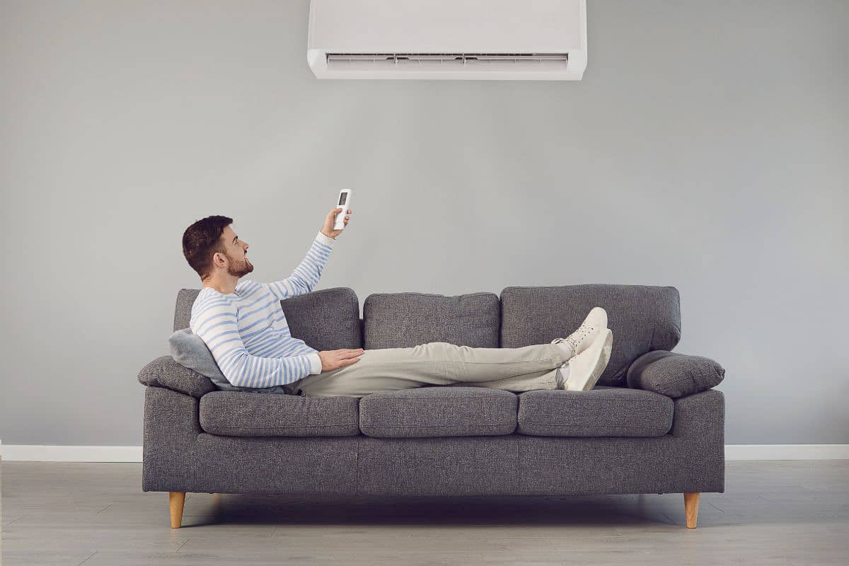 man on couch with AC unit.
