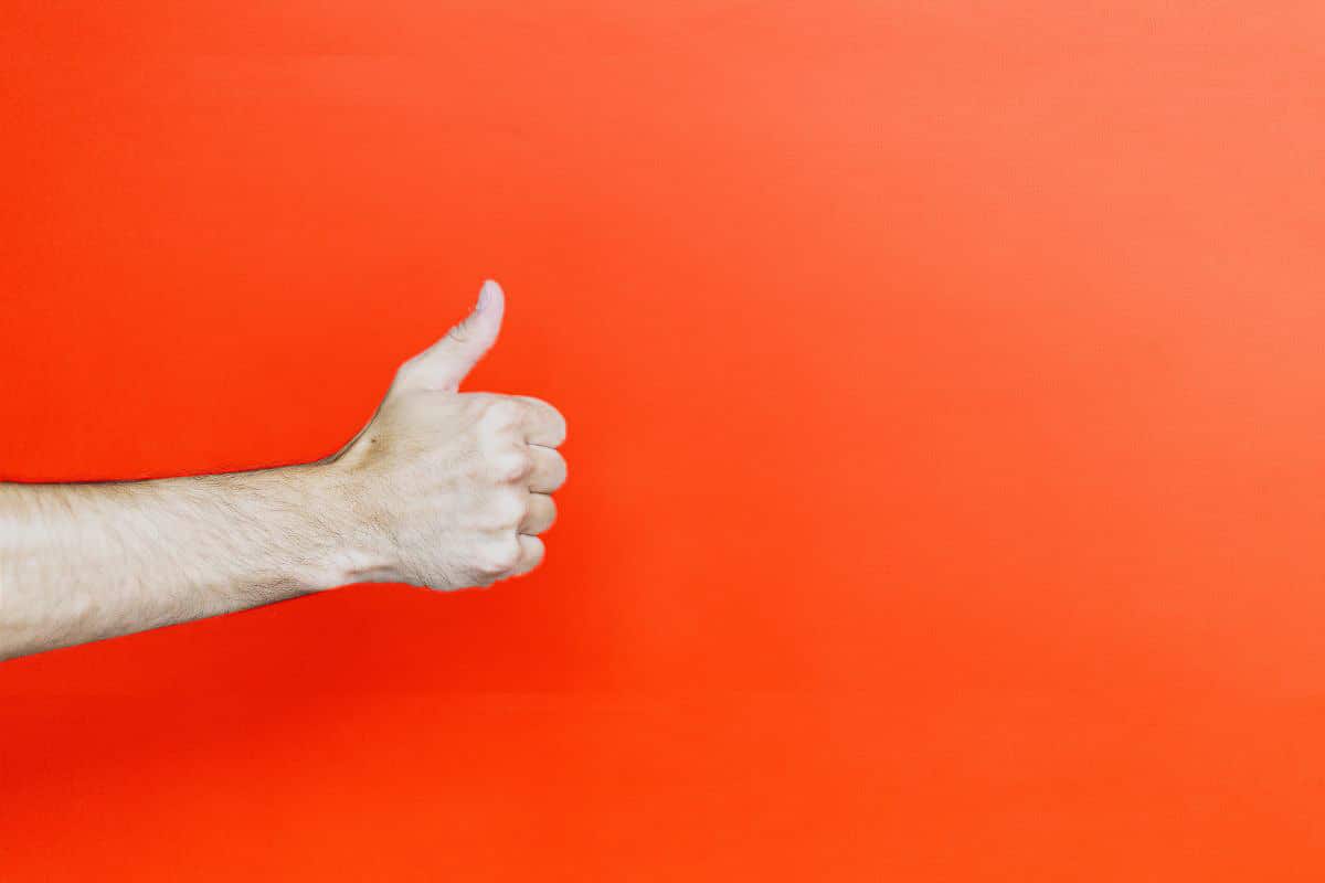 thumbs up on red background.