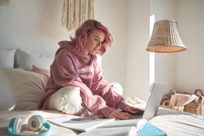 teen in bed with laptop