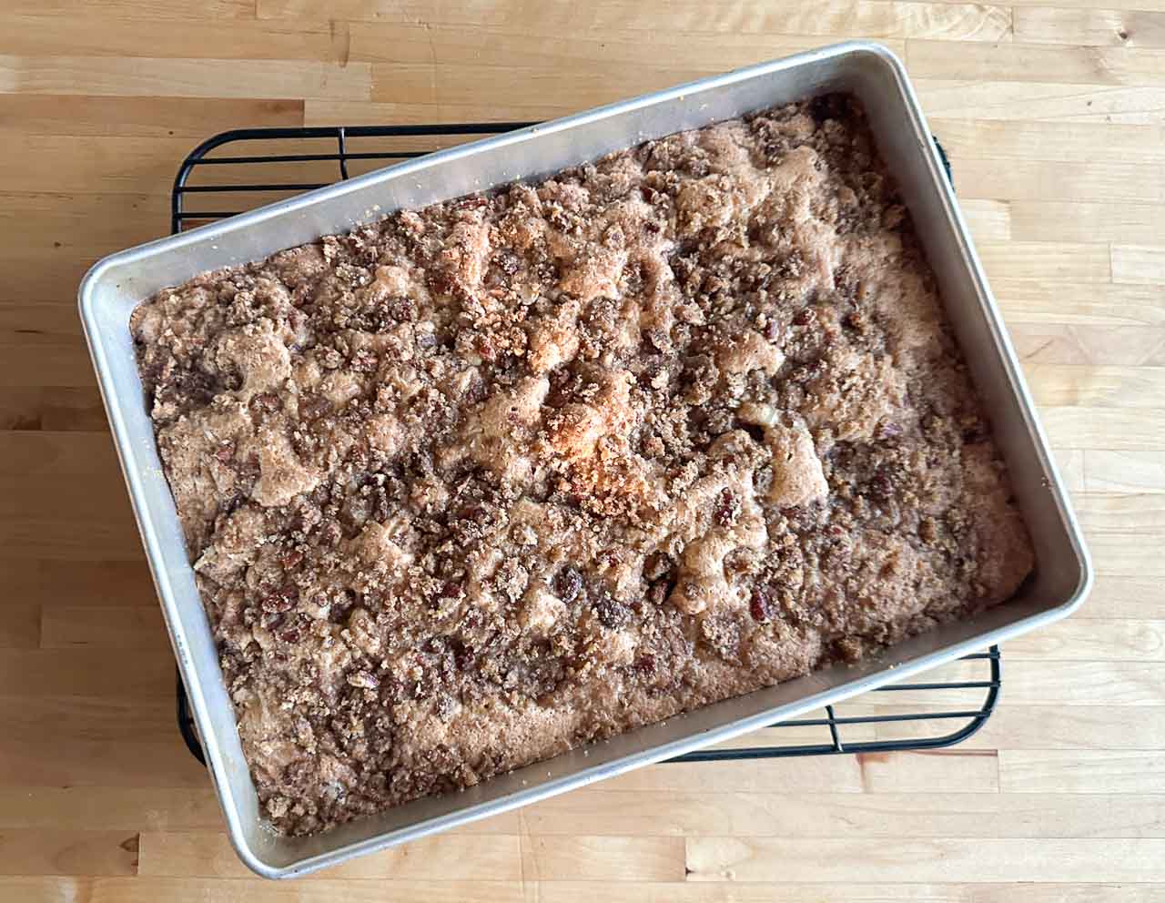 brown sugar pecan streusel topping over apple cake batter in pan after baking.