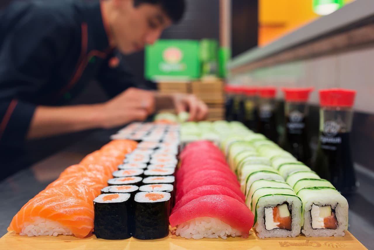 chef making sushi wearing dark jacket.