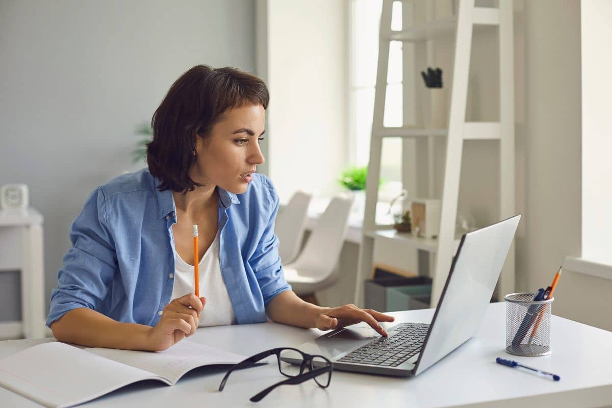 woman looking at laptop at desk.