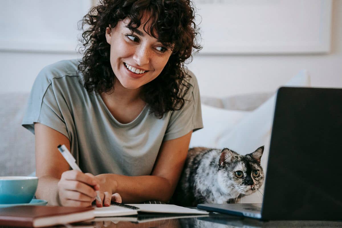 woman with cat looking at computer.