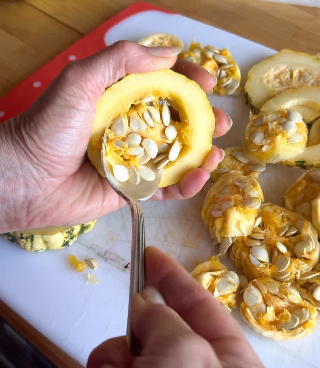 scooping seeds out of Delicata squash.
