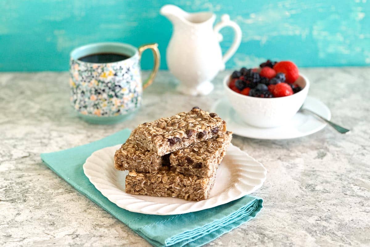 Low FODMAP Breakfast Bars stacked on white plate, with aqua napkin