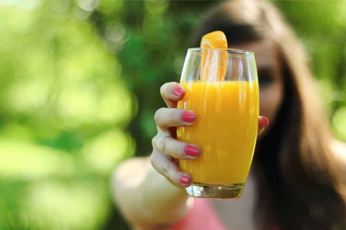 woman holding orange juice.