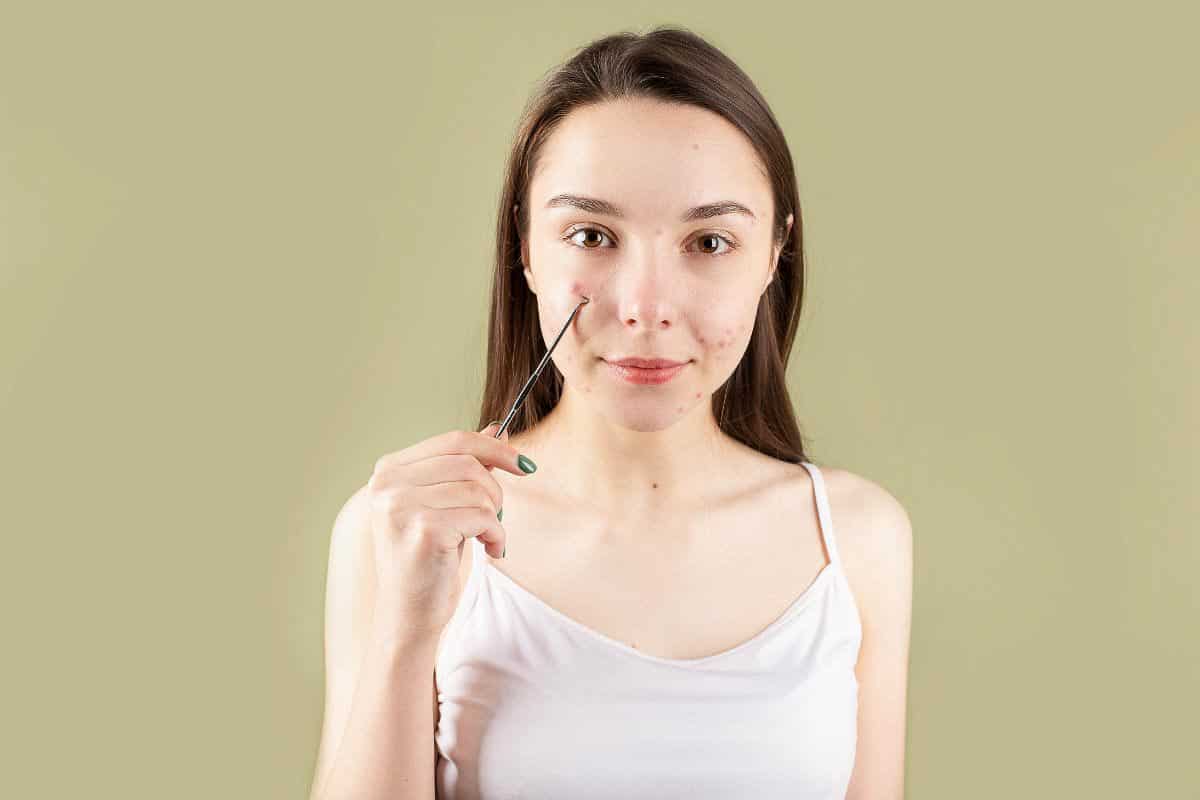 woman using tool for pimples.