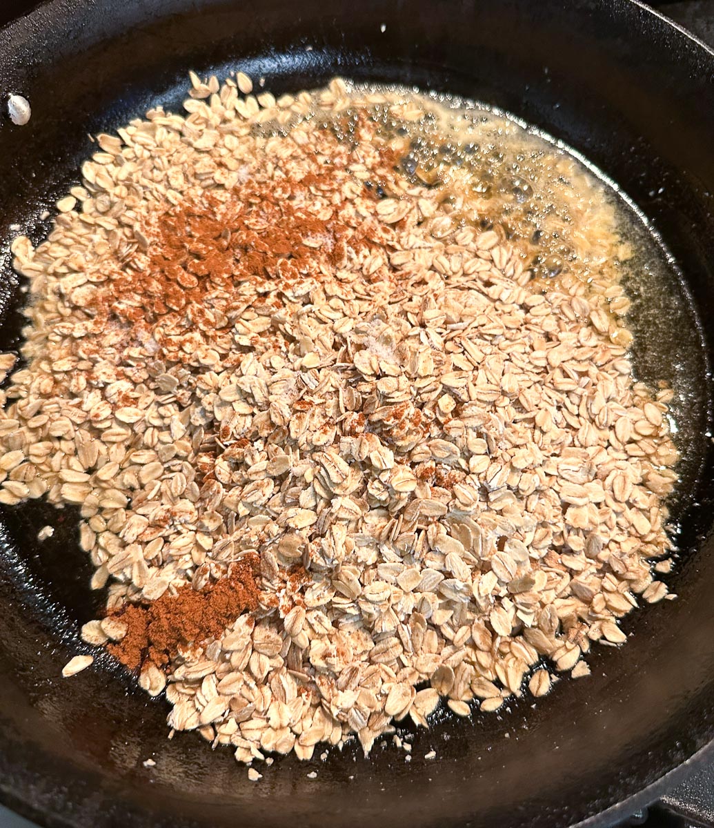 Adding oats and cinnamon to pan with butter and honey.