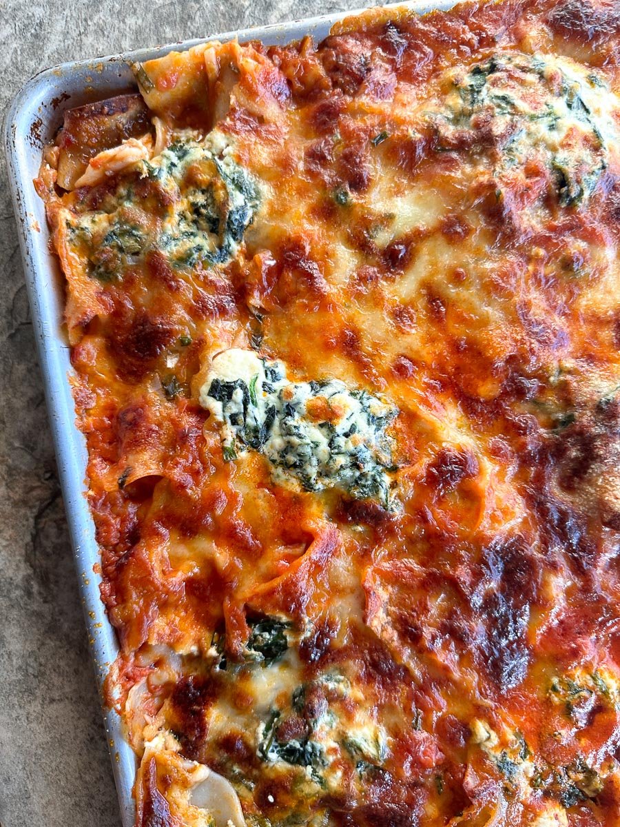 Baked low FODMAP Sheet Pan Lasagna with sausage on pan; closeup of ricotta.