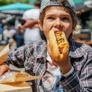 Boy eating a hot dog.