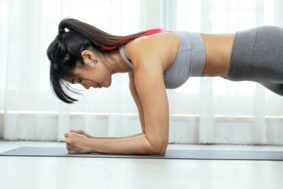 side view of woman holding a plank position.