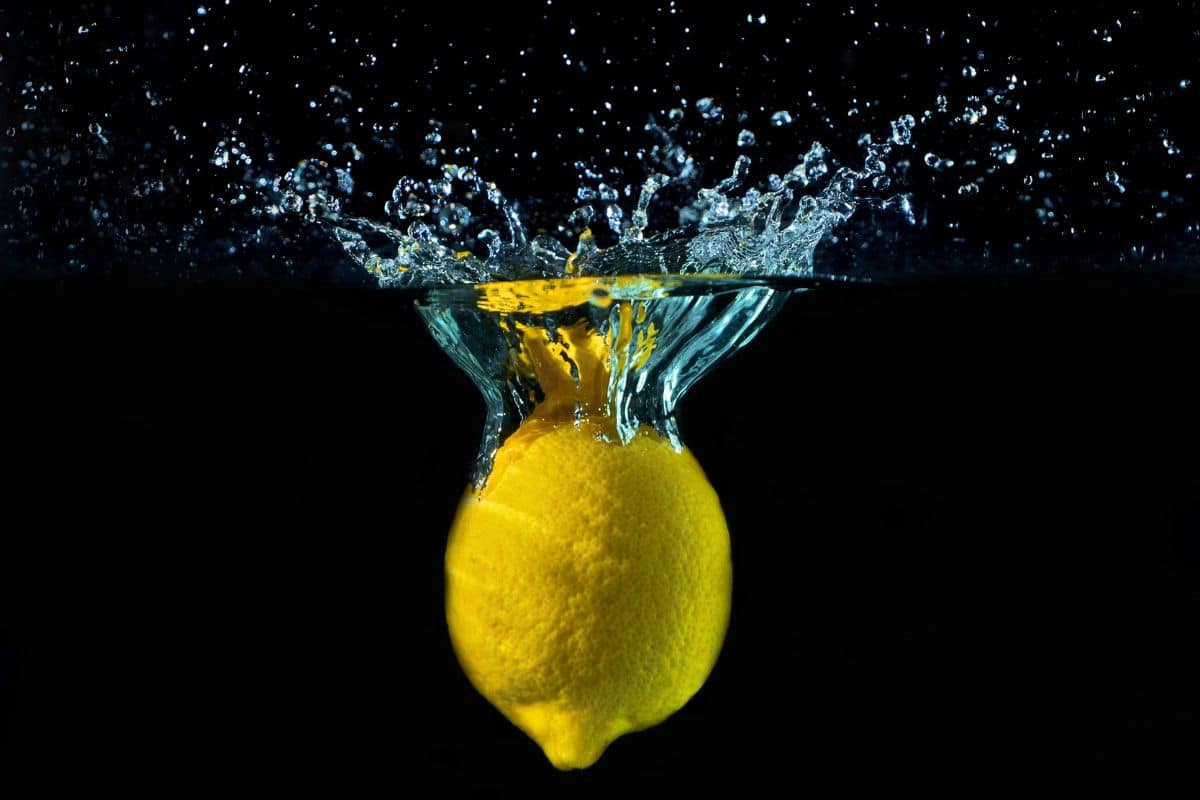 Lemon dropping in water.