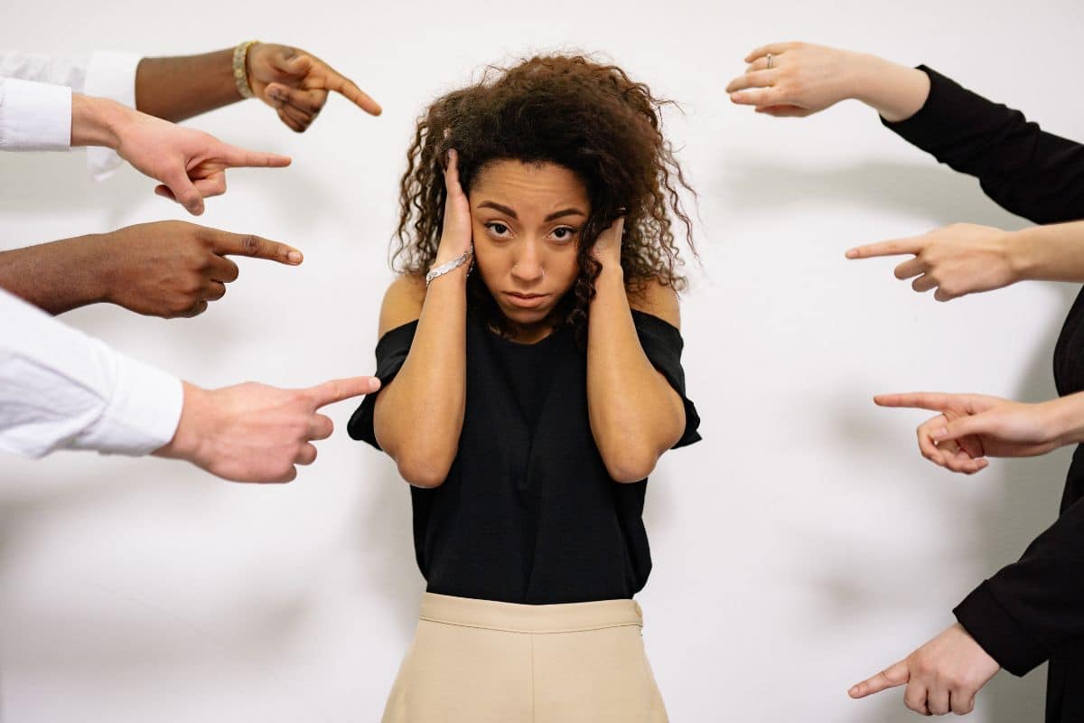 Many people pointing fingers at woman. 