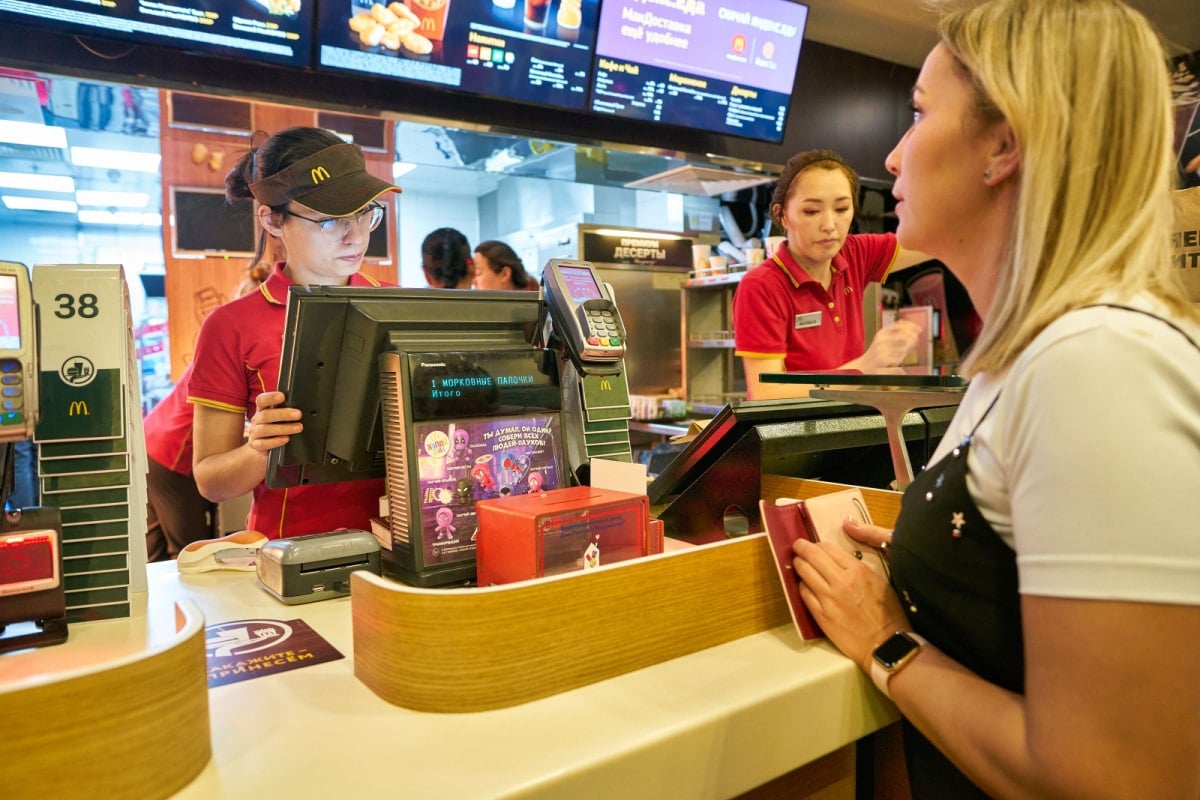  staff taking an order from woman at McDonald's restaurant in Moscow.