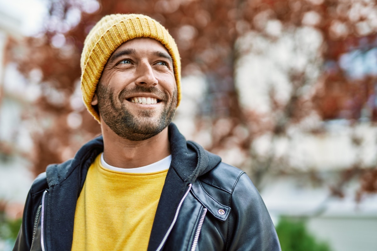 Handsome hispanic man with beard smiling happy outdoors.