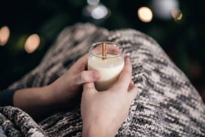 Drinking Eggnog By The Christmas Tree Photo The holidays are the perfect time to cozy up on the couch with a rich glass of eggnog..