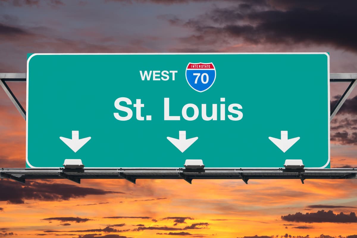 St Louis Interstate 70 west highway sign with sunrise sky.