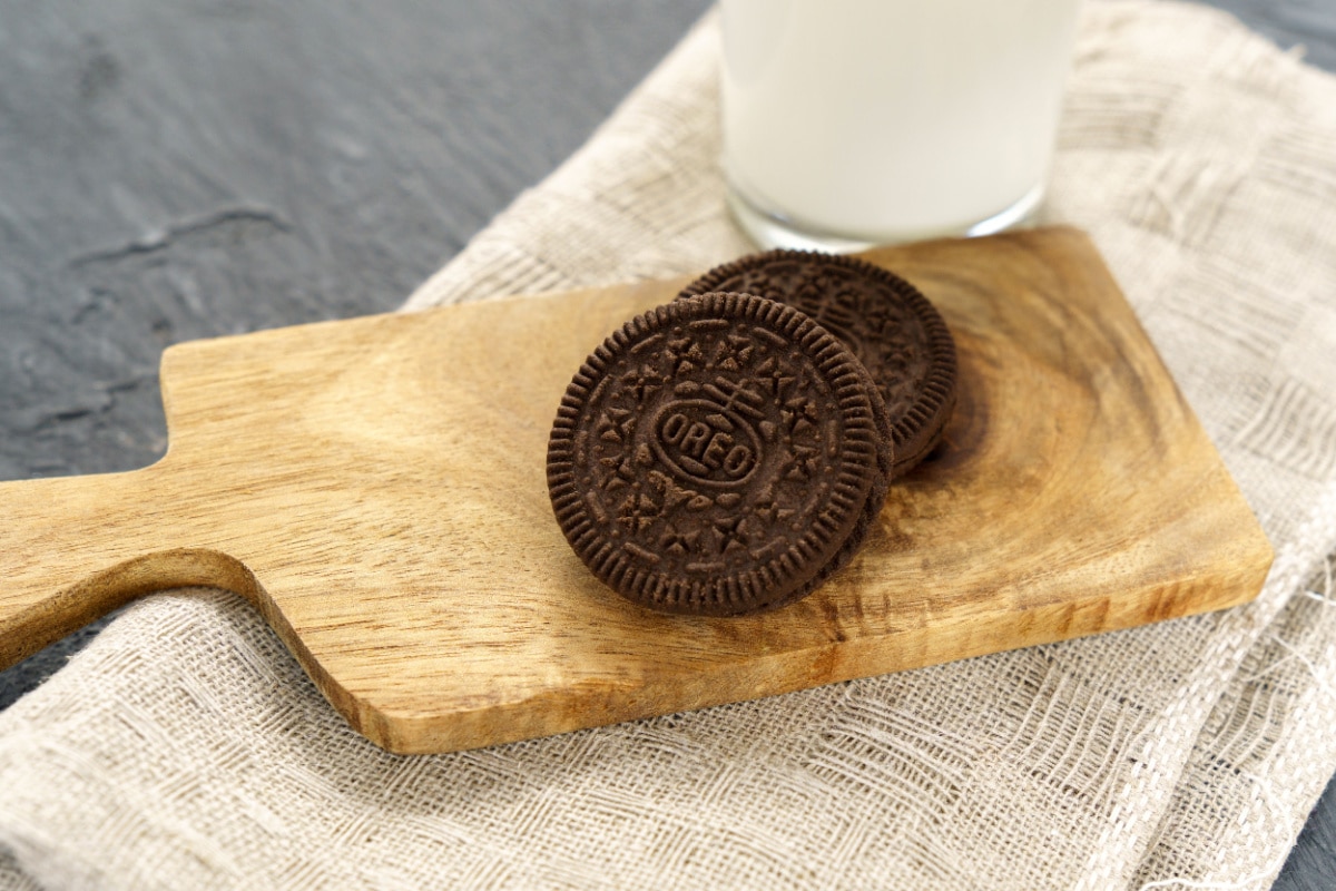 Two oreos on wooden board. 