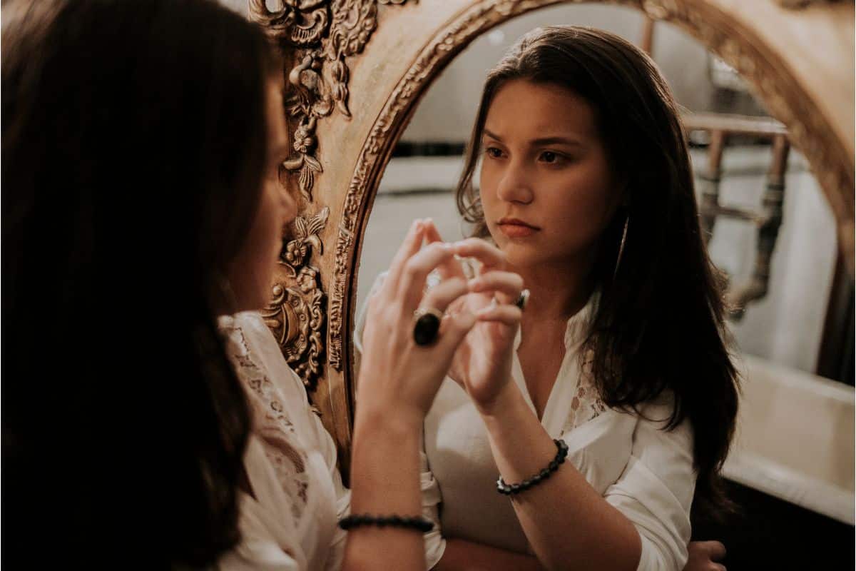 Woman looking in mirror. 