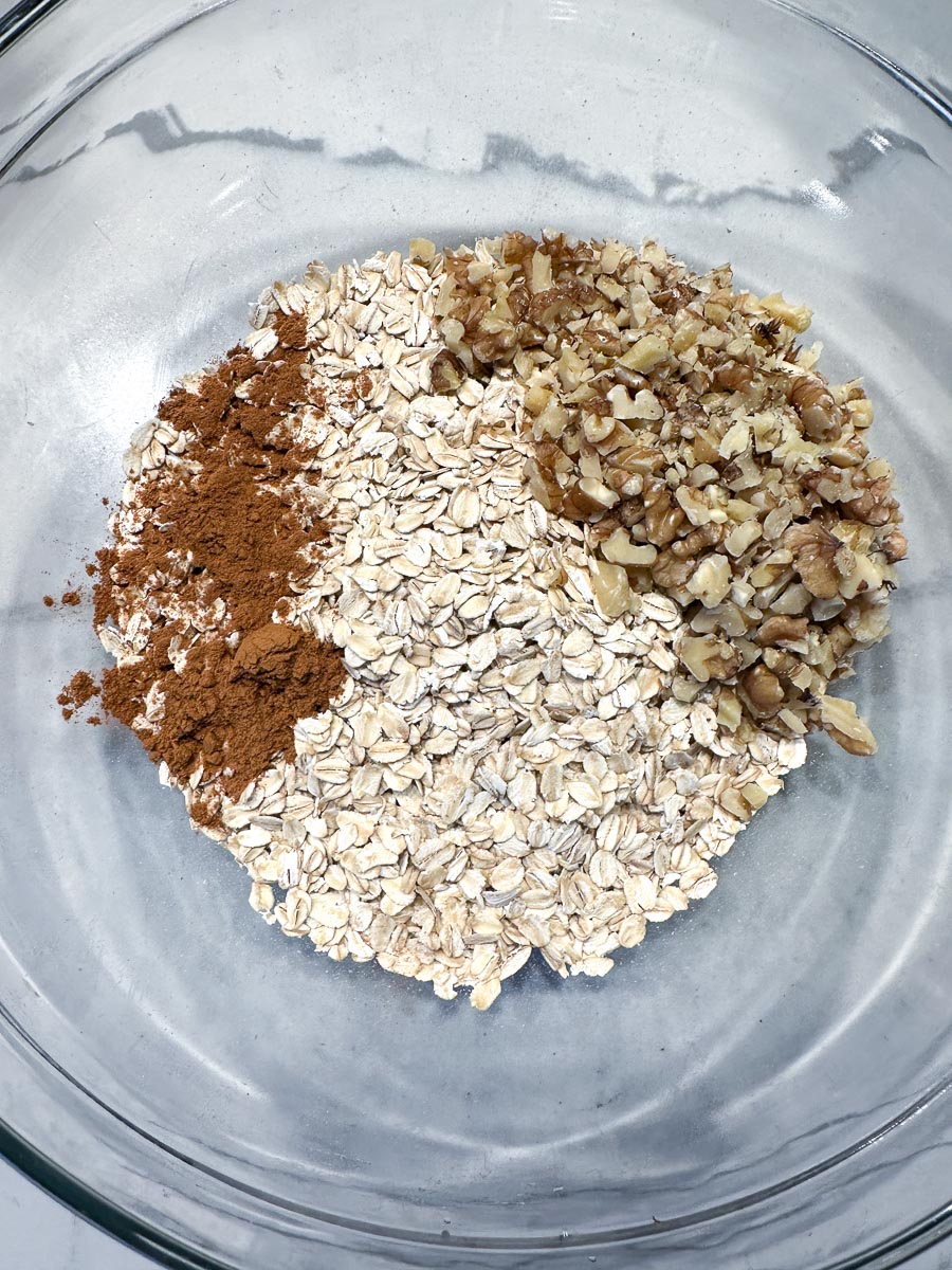 dry ingredients for maple walnut granola in glass bowl.
