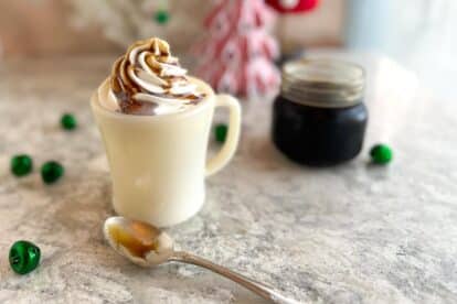 horizontal image of Low FODMAP Gingerbread Syrup drizzled on top of a latte with whipped cream.
