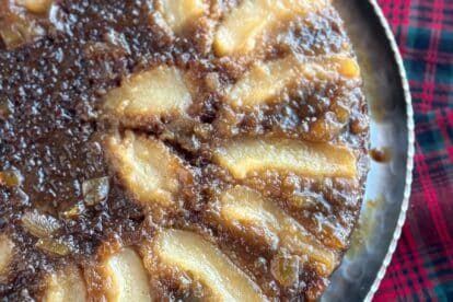 partial image of Lower FODMAP Gingerbread Pear Upside Down cake on platter.