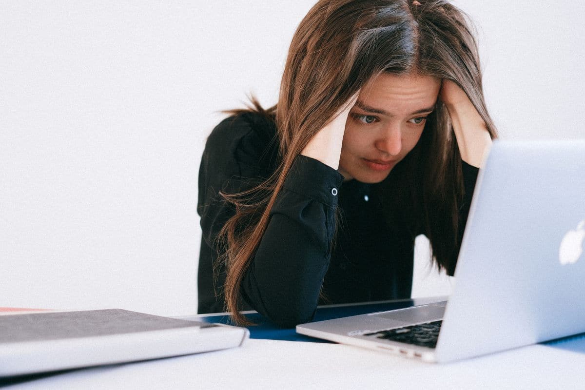 stressed woman looking at laptop.