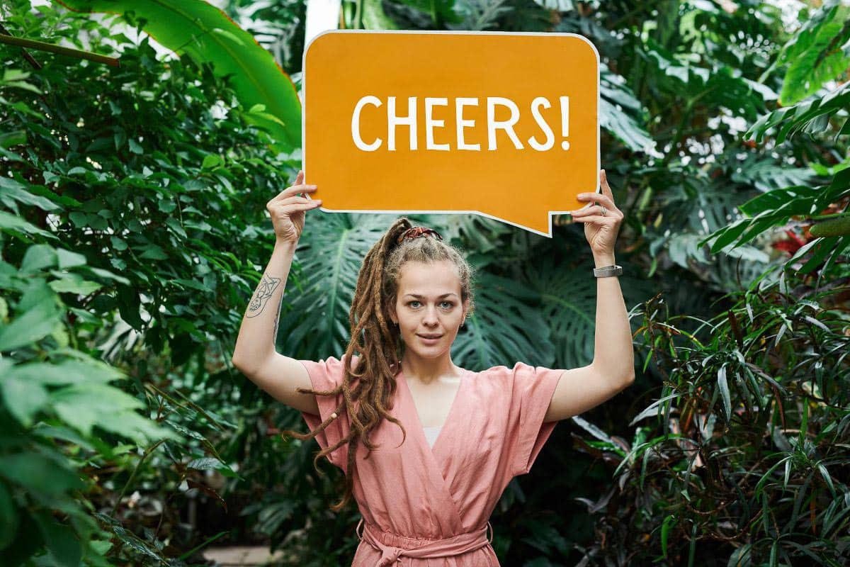 woman holding "cheers" sign. 