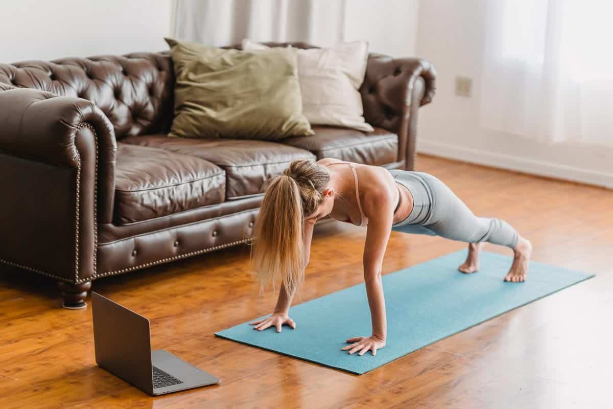 woman holding plank on blue mat. 