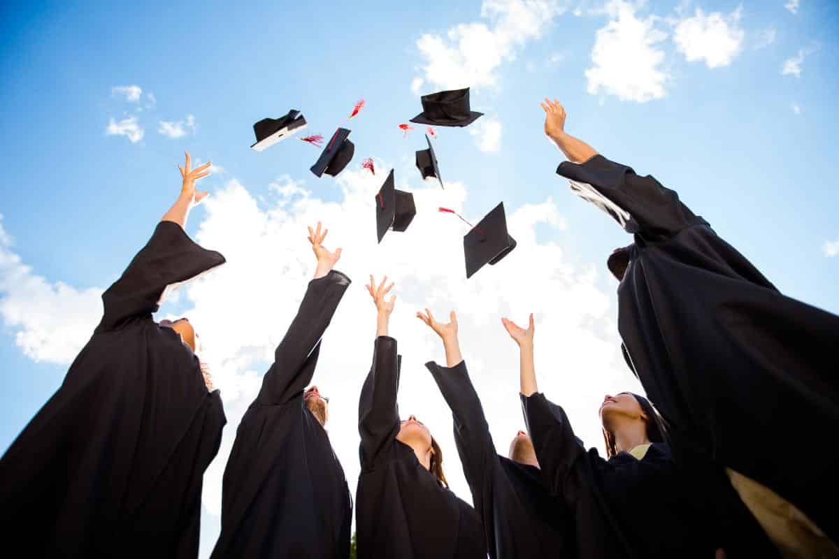 Graduates throwing hats in air. Shutterstock_789412672.