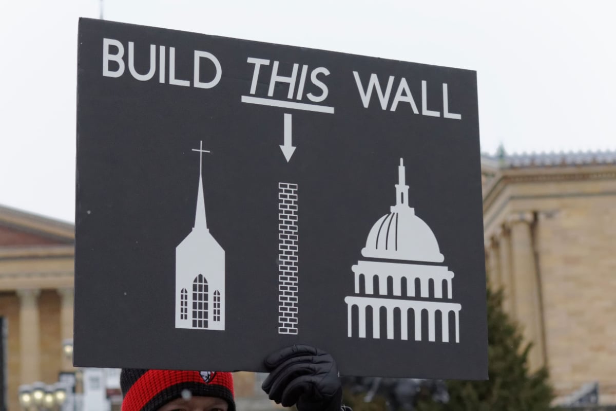 A sign mocking Donald Trump's border wall and supporting separation of church and state 