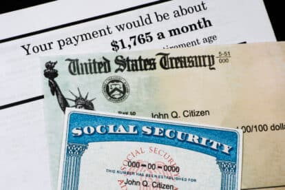 A Corner of Social Security Administration annual statement showing benefits amount at full retirement age with check and ssn card. Concept of retirement planning.