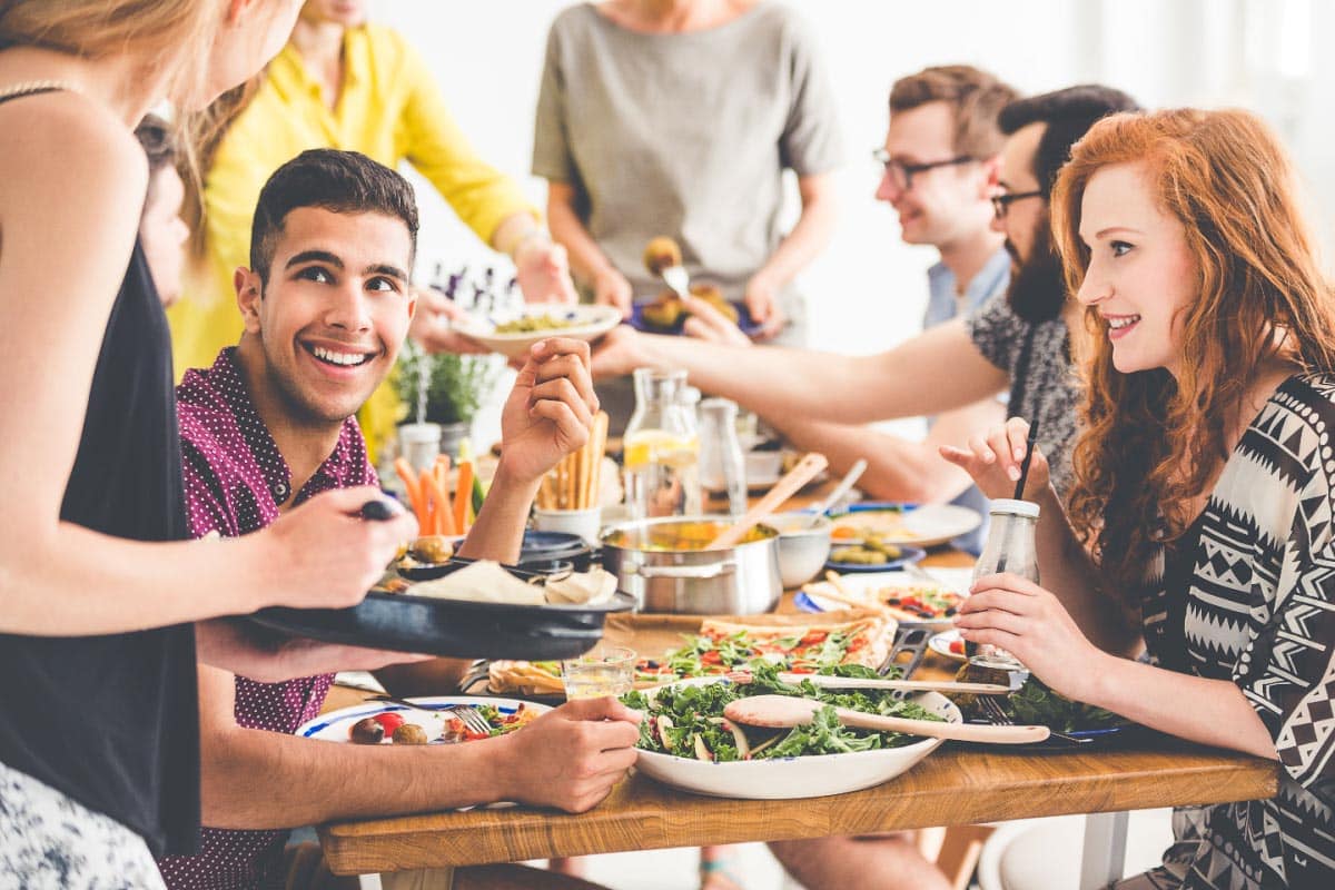 happy people eating a meal. Shutterstock_693458410.