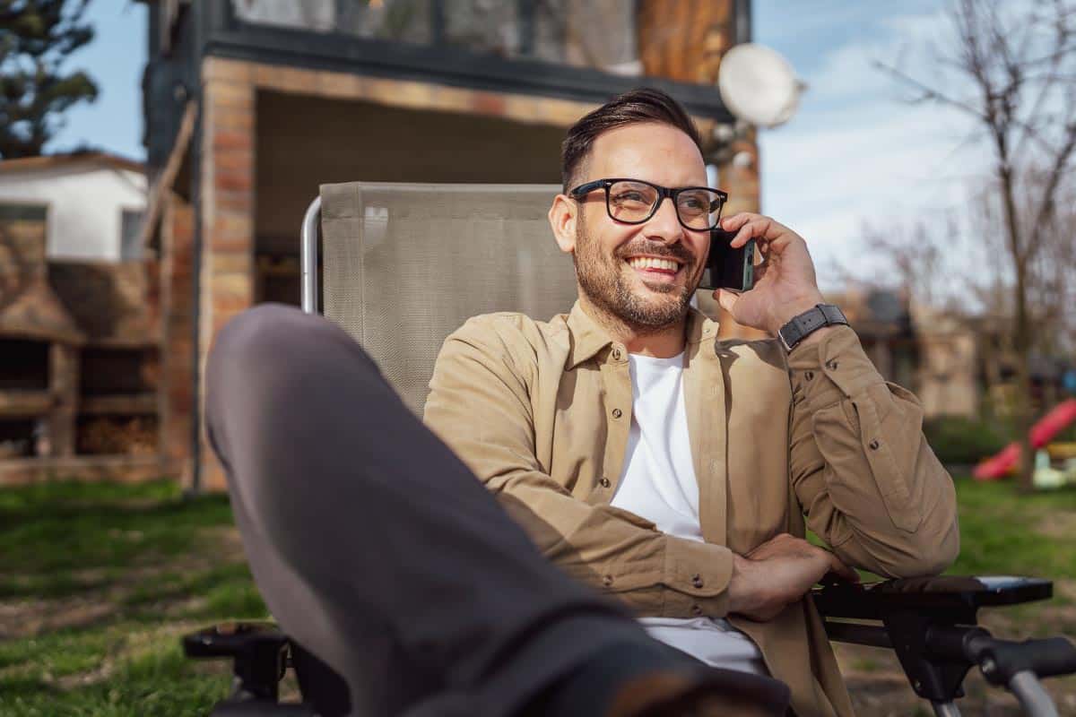 man in chair on phone. Shutterstock_2306804243.