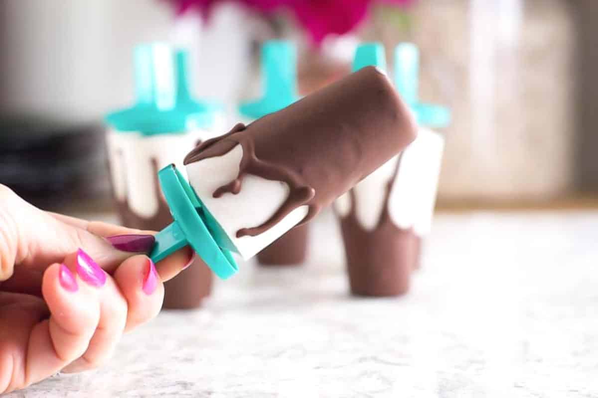 manicured-hand-holding-a-Low-FODMAP-Chocolate-Covered-Banana-Popsicle_.