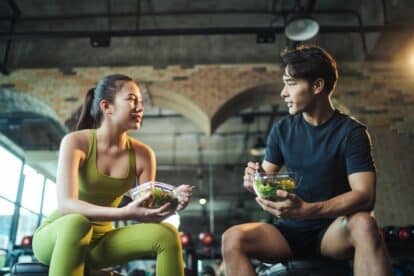 two people eating salads at the gym. Shutterstock_2200469757.