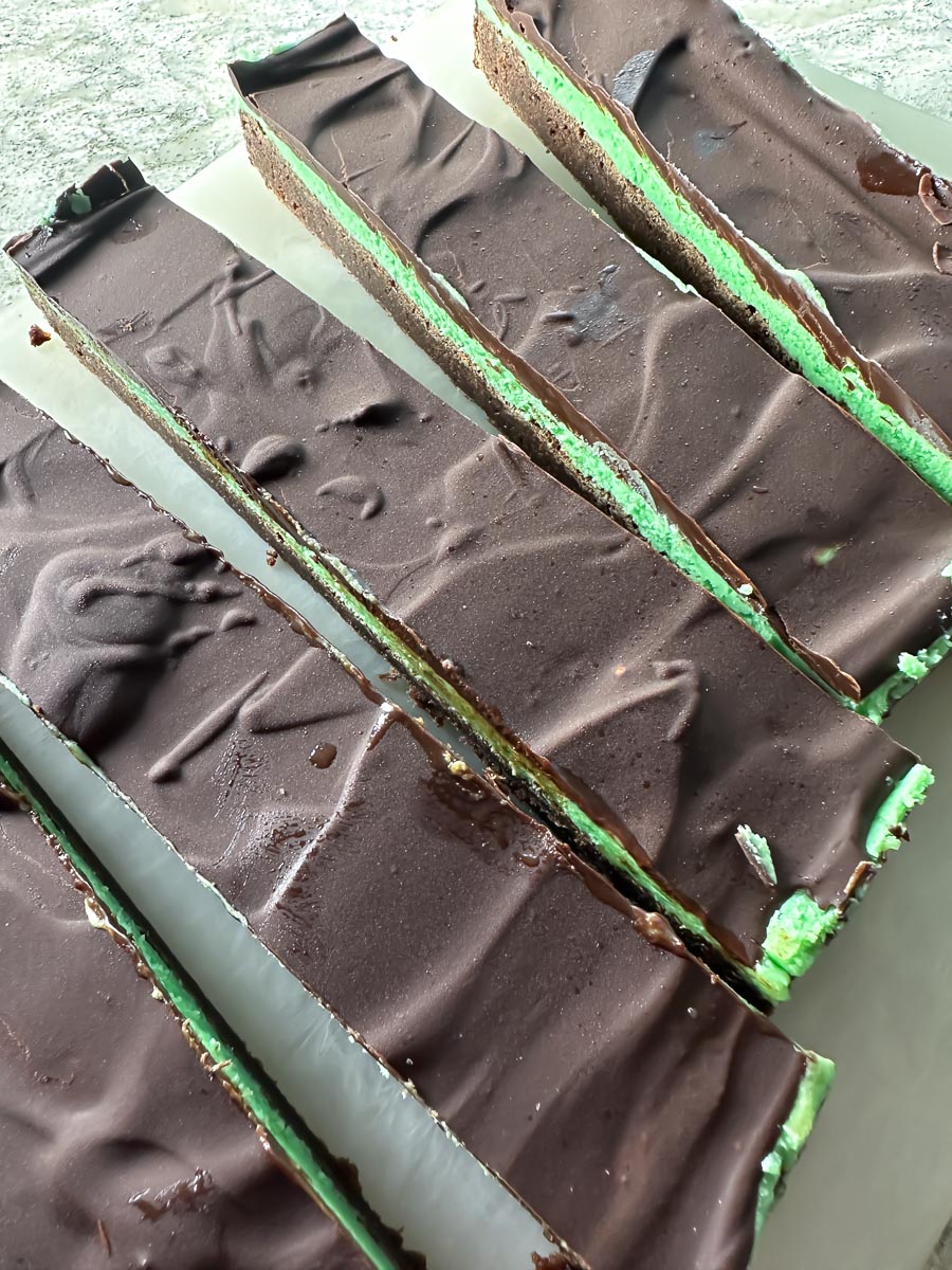 Low FODMAP Mint Brownies being cut on board showing all layers.