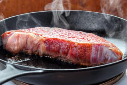 Searing steak in cast iron skillet.
