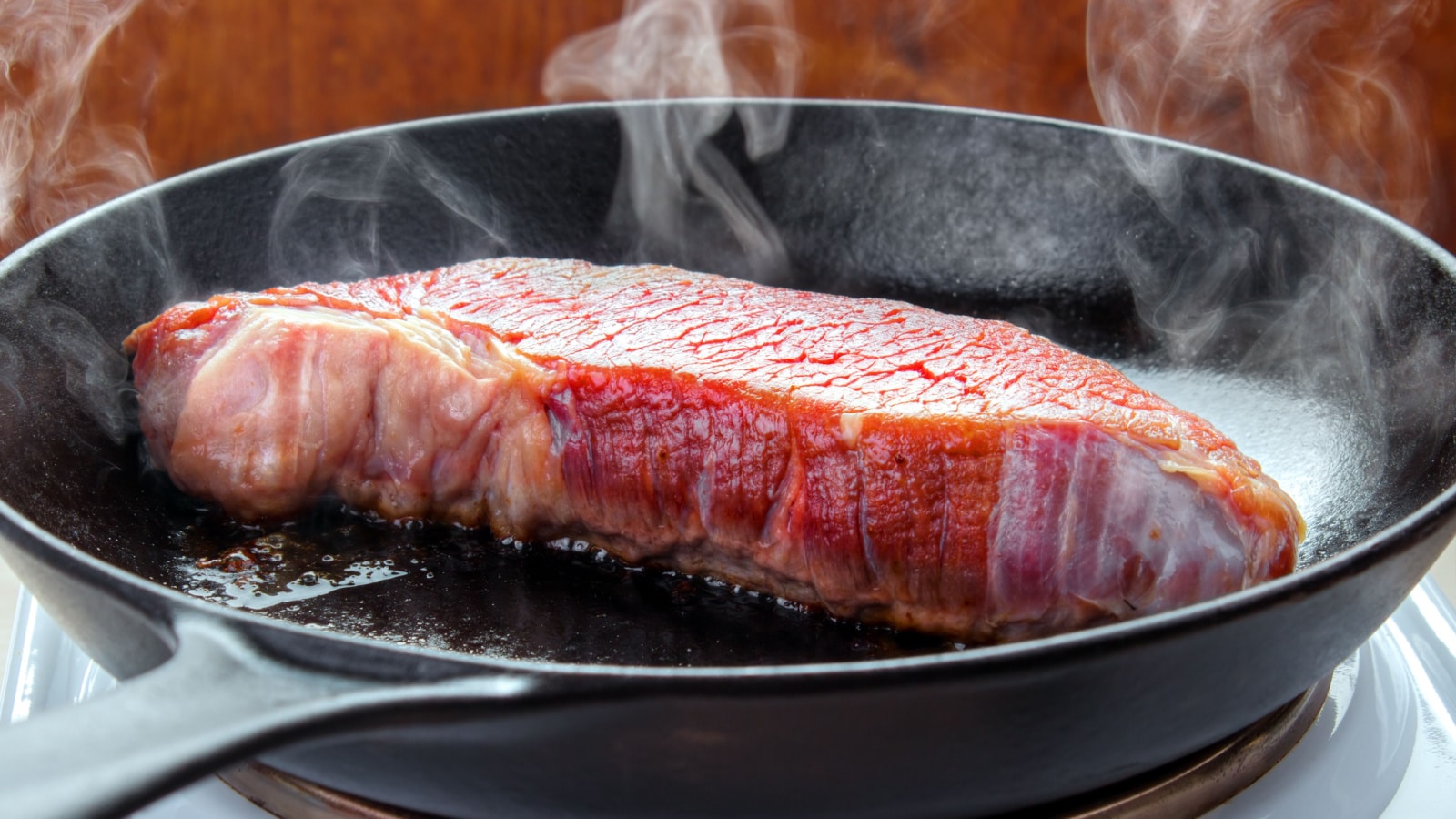 Searing steak in cast iron skillet. 