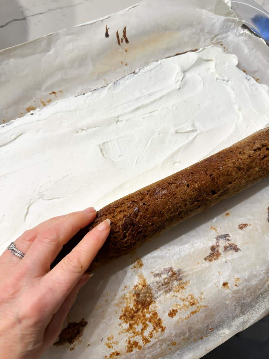 rolling up gingerbread cake roll around filling.